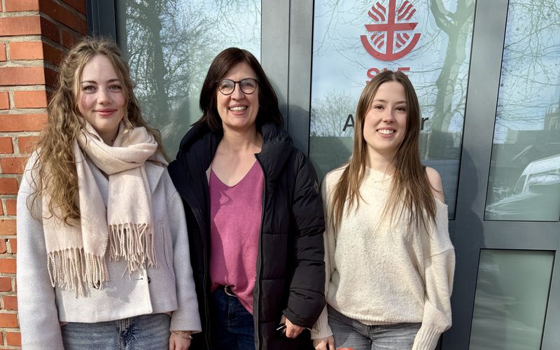 Frau van der Linde und 2 Schülerinnen stehen vor der Tür der Tafel