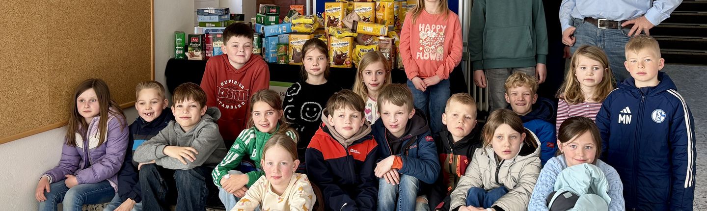 Kinder, Johannes Lügering u. Frau Wilhelmus stehen neben Kakao und Kaffee