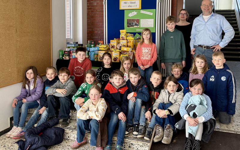 Kinder, Johannes Lügering u. Frau Wilhelmus stehen neben Kakao und Kaffee