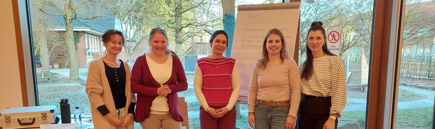 4 Koordinatorinnen stehen in einer Reihe und halten einen Vortrag