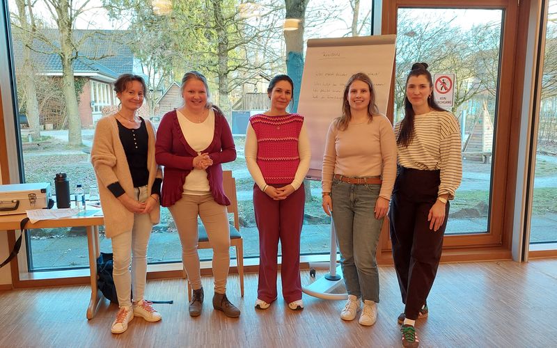 4 Koordinatorinnen stehen in einer Reihe und halten einen Vortrag