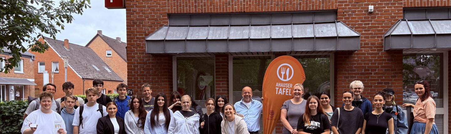 Viele Schüler und der Leiter der Ahauser Tafel stehen vor dem Gebäude