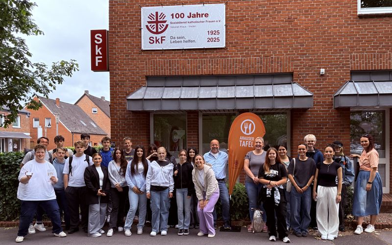 Viele Schüler und der Leiter der Ahauser Tafel stehen vor dem Gebäude