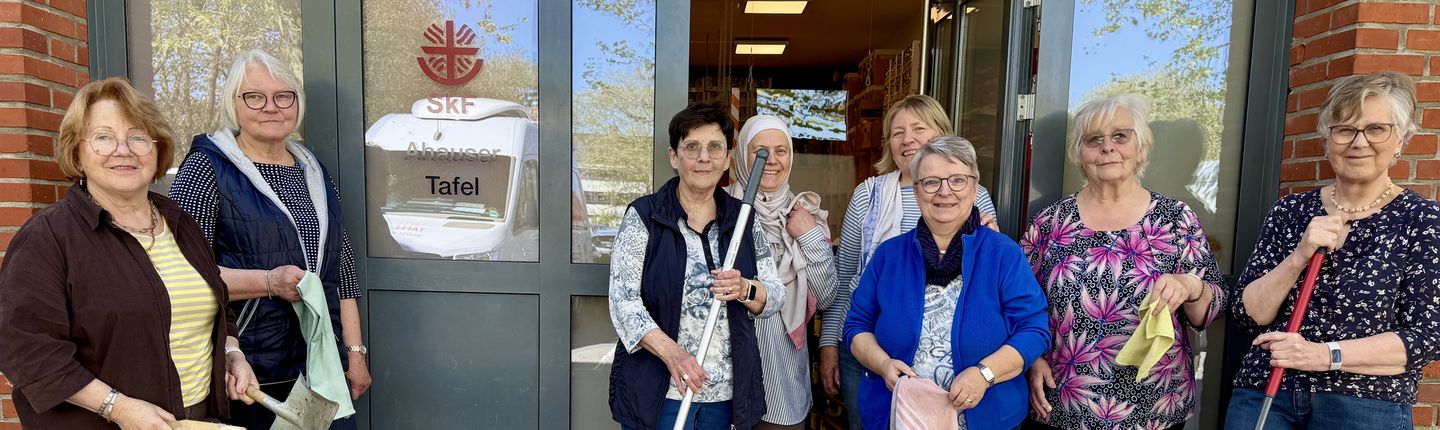 8 Frauen stehen mit Putzutensilien vor der Ahauser Tafel
