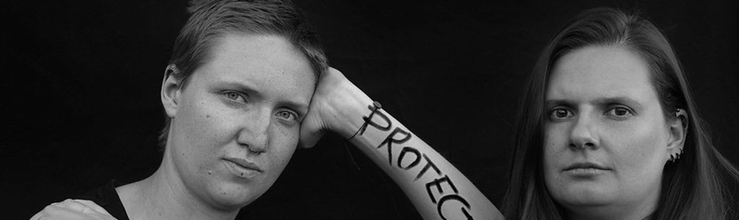 2 Frauen haben auf ihren Unterarmen Protect us alive geschrieben