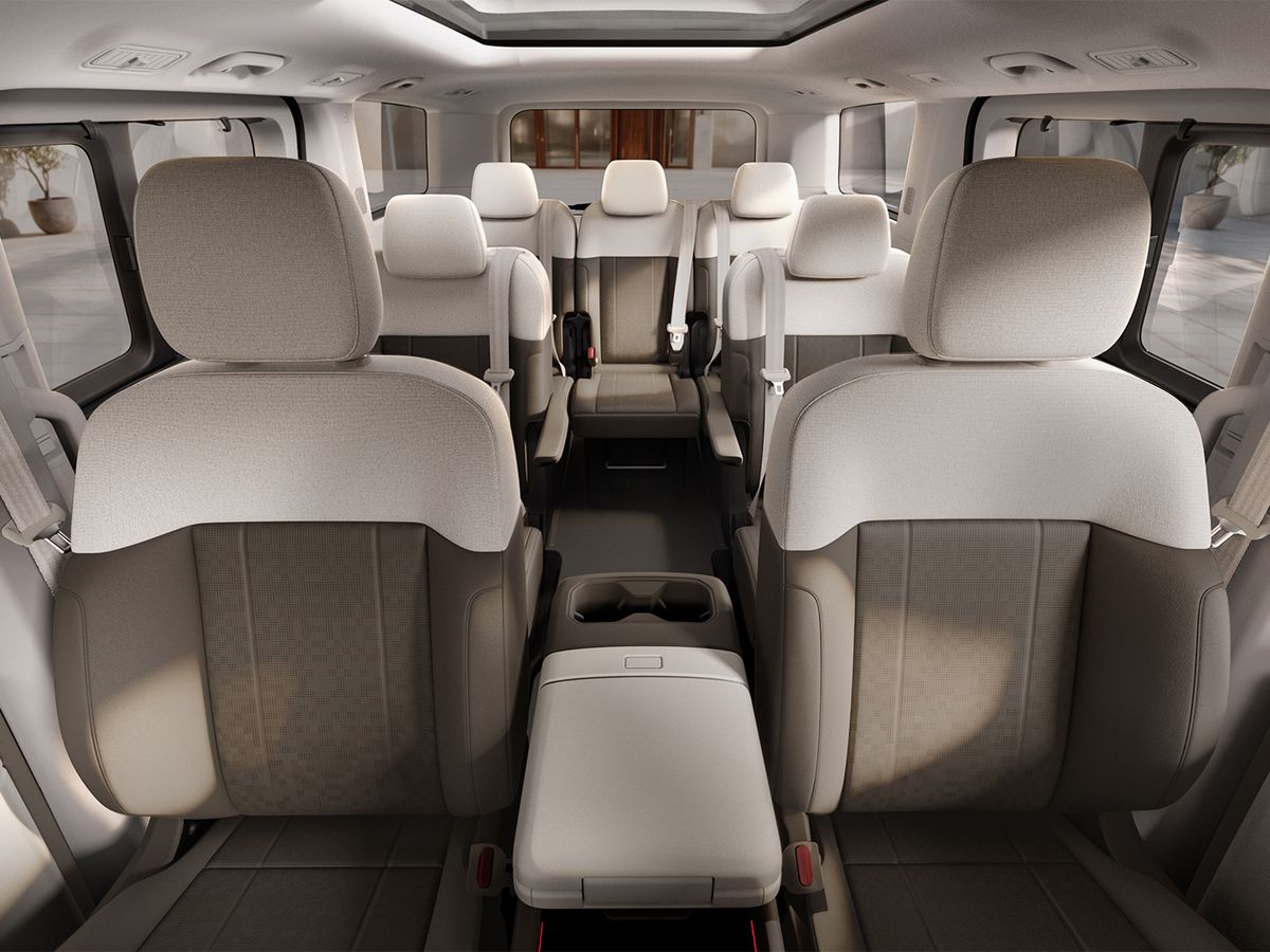 Interior view of an SUV, featuring beige leather seats arranged in three rows for up to nine passengers, with a spacious and modern design.