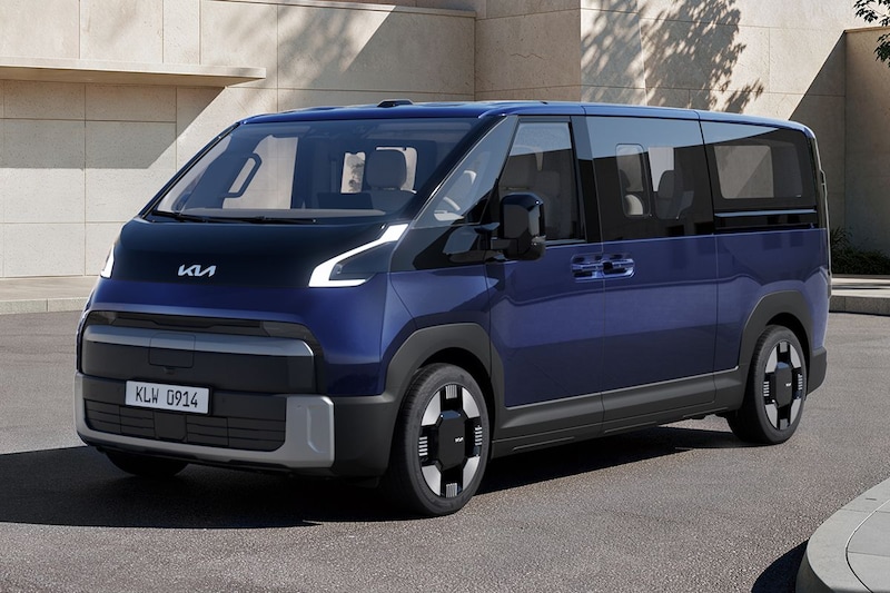 A modern blue van with a sleek design, parked on a street next to a beige building, featuring large windows and distinctive wheels.