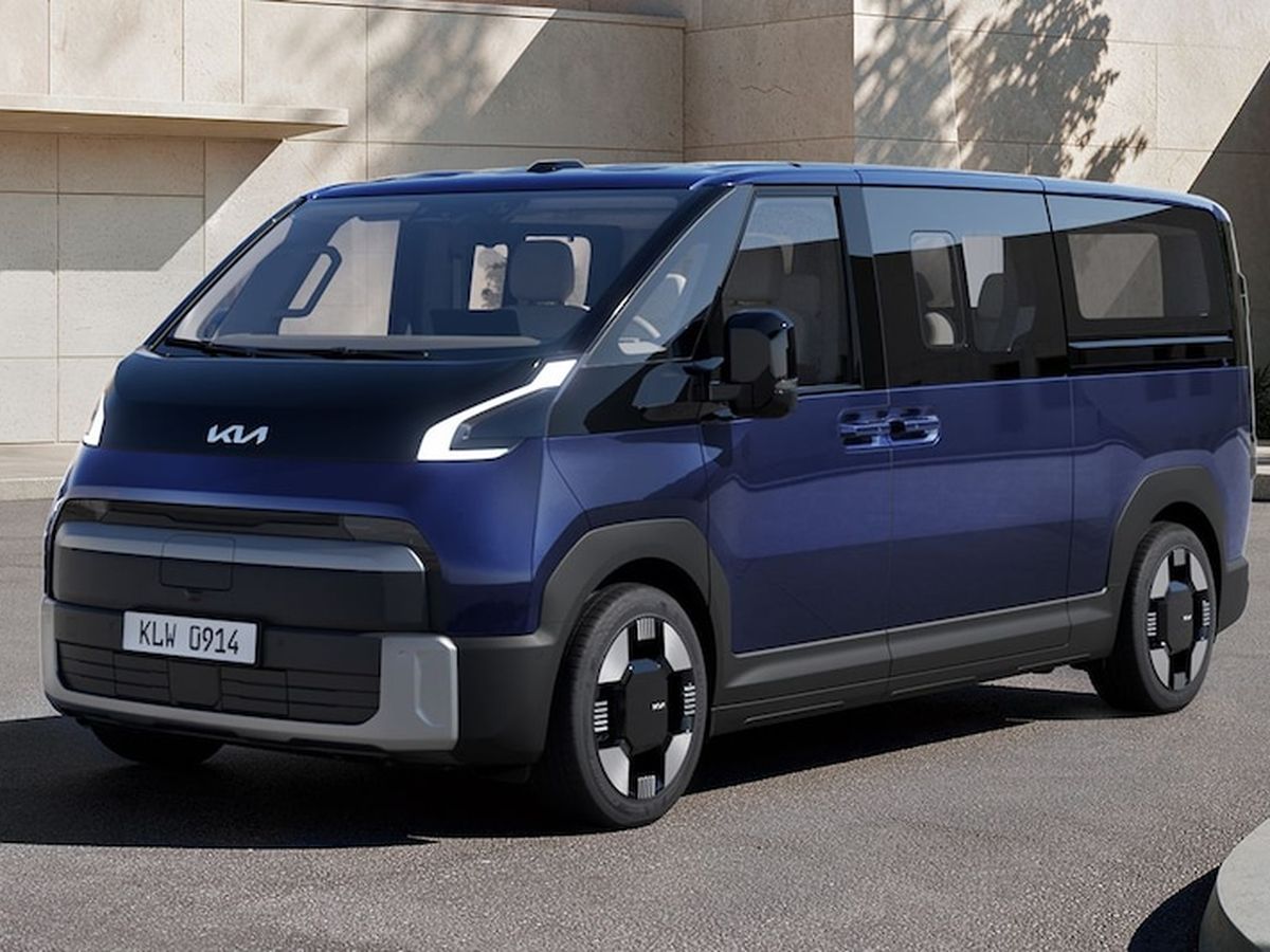 A modern blue van with a sleek design, parked on a street next to a beige building, featuring large windows and distinctive wheels.