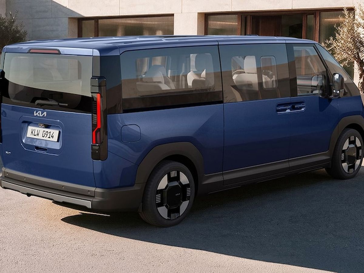 A blue minivan with a modern design, featuring large windows and distinctive taillights, parked in front of a modern building.