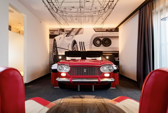 A racecar bed with a giant photo of a racecar behind it.
