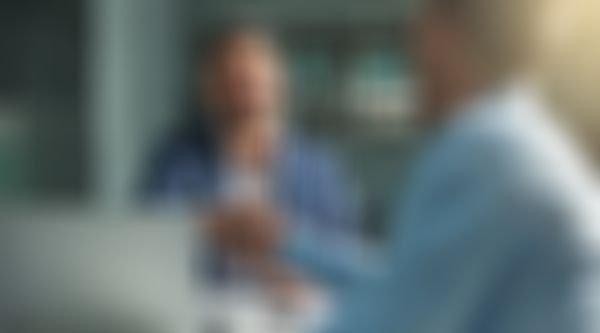 Zwei Geschäftsmänner sitzen am Schreibtisch und geben sich die Hände.