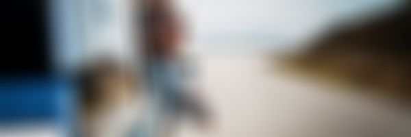 Verkehrs-Rechtsschutz - Frau lehnt sich aus Beifahrerfenster und genießt die Aussicht