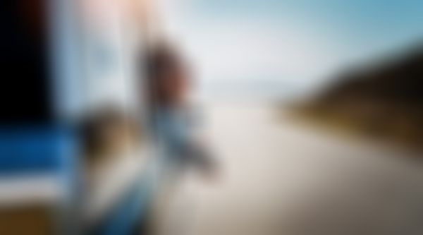 Verkehrs-Rechtsschutz - Frau lehnt sich aus Beifahrerfenster und genießt die Aussicht