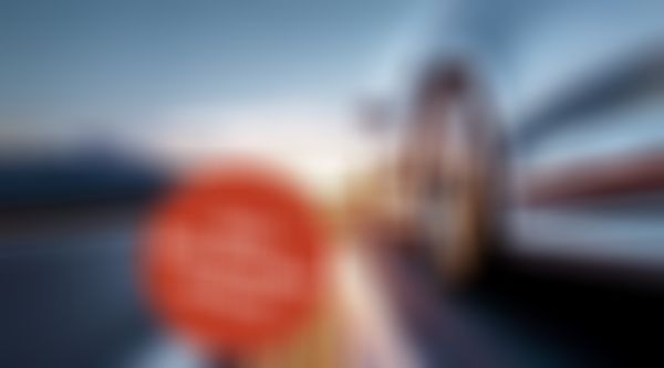 Auto fährt auf Straße in den Sonnenuntergang.