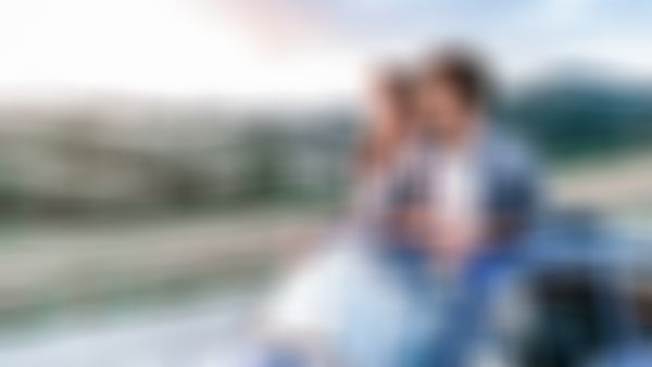 Oldtimer-Versicherung Top Klassik - Pärchen in Oldtimer Kleinwagen betrachetet schöne Landschaft