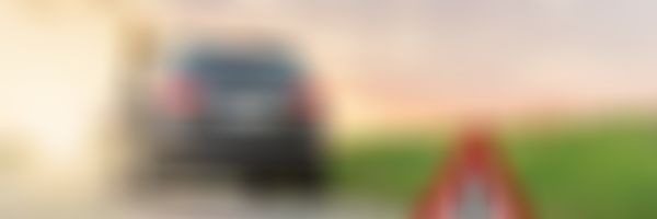 Frau lehnt an Auto, Autopanne, Pannendreieck.