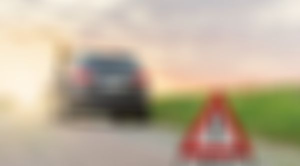 Frau lehnt an Auto, Autopanne, Pannendreieck.