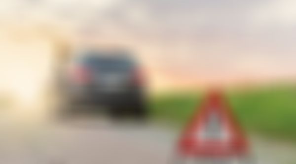 Frau lehnt an Auto, Autopanne, Pannendreieck.