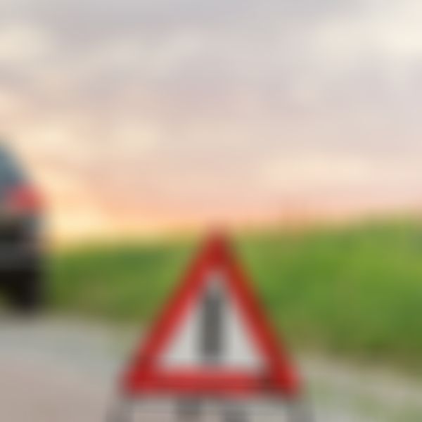 Frau lehnt an Auto, Autopanne, Pannendreieck.