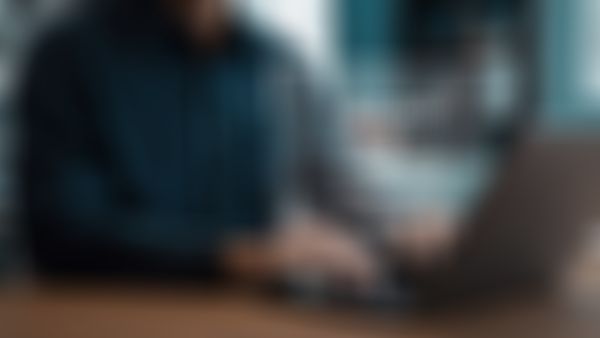 Mann sitzt vor einem Loginbildschirm am Laptop