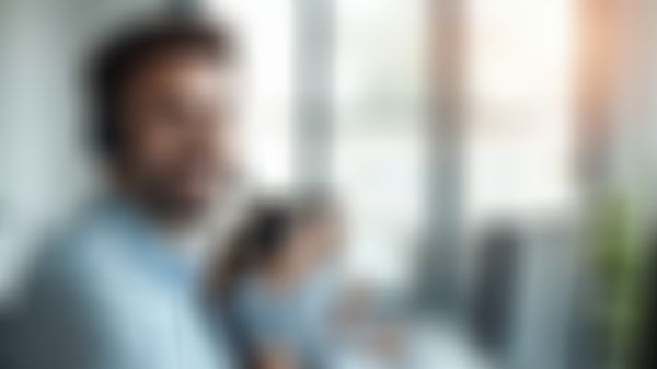 Mann mit Headset sitzt vor dem Computer und wartet auf Kundenanrufe