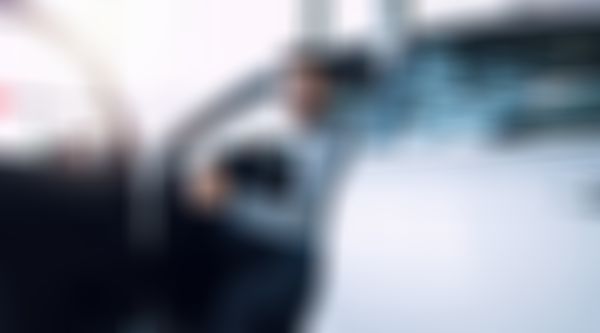 Teilkasko-Versicherung - Mann mit Brille sitzt lächelnd auf Fahrersitz