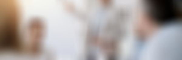 Mann trägt vor Gruppe vor und zeigt auf Flipchart.