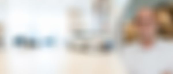 Im Hintergrund ein unscharf gezeichnetes Autohaus unbestimmter Marke. Am rechten Bildrand der Gebietsleiter Mario Weber.