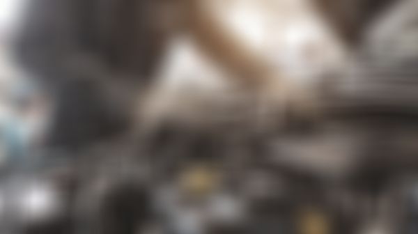 Mann steht vor offener Motorhaube eines Autos.