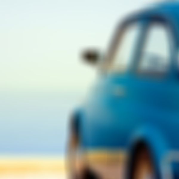 blauer Oldtimer mit Blick aufs Meer