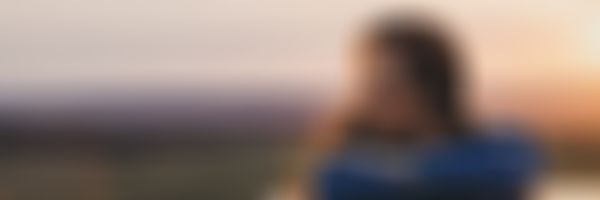 GARANTA Image Sujet - Campende Frau sitzt auf ihrem Autodach und betrachtet das Bergpanorama