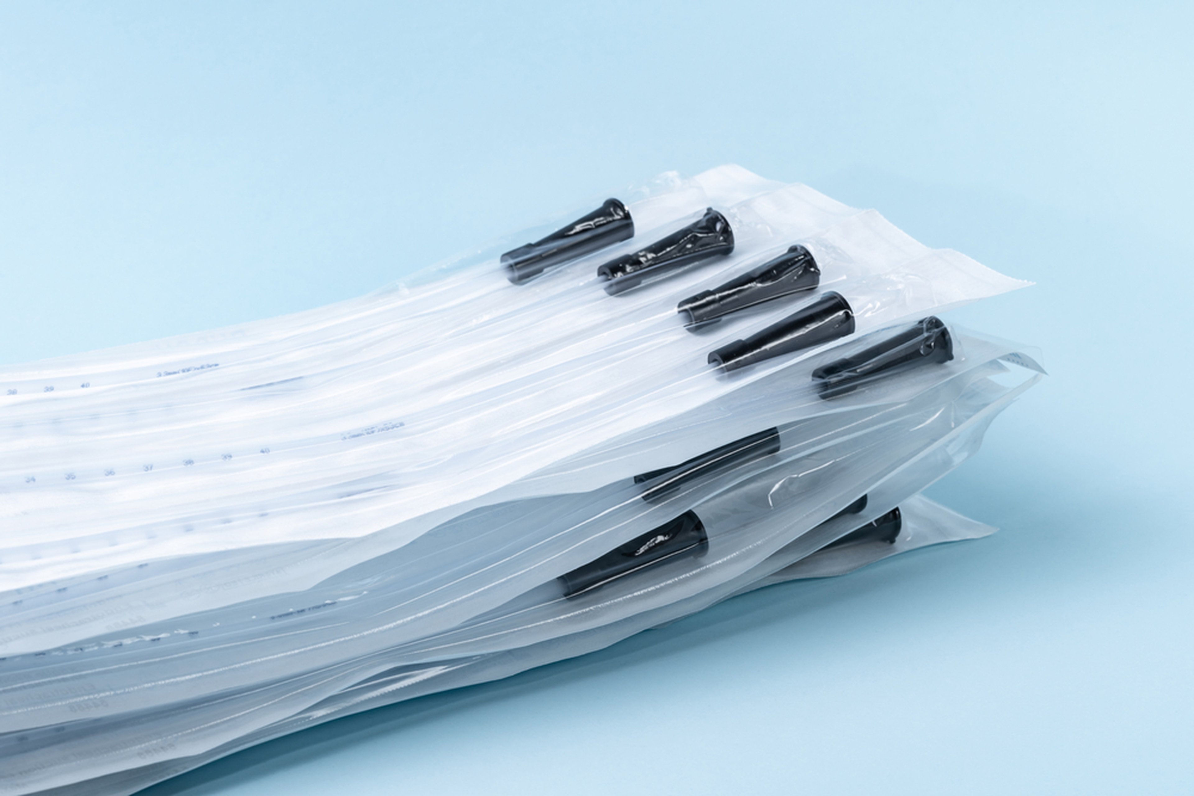 Rusch male and female all purpose catheter on blue background, straight tipped intermittent catheters designed for a single use, packaged individually and sterile