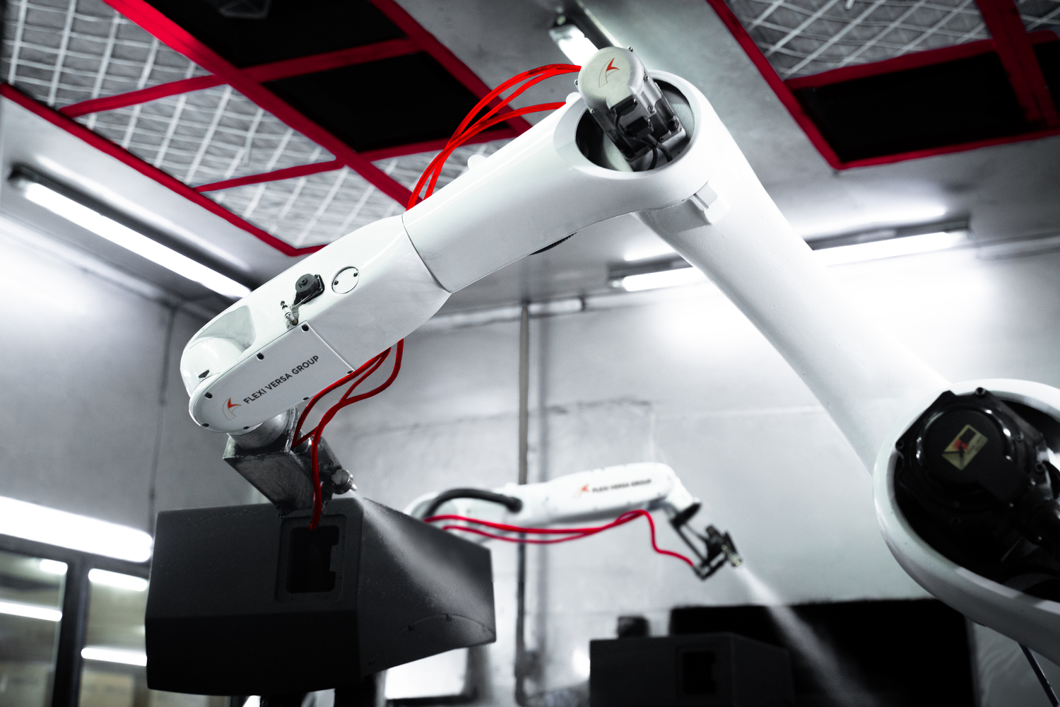 Robotic Spray Painting Arms with Red Cables Robotic arms equipped with spray painting tools and red cables operating in a modern industrial environment.
