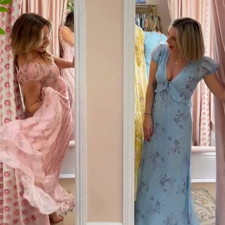 Two women in floral dresses smile at each other from adjacent fitting rooms, surrounded by pink floral curtains.