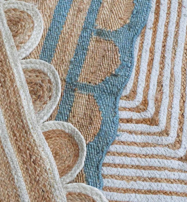 Close-up of a textured woven rug with blue, brown, and white patterns, featuring spirals, stripes, and scalloped edges.