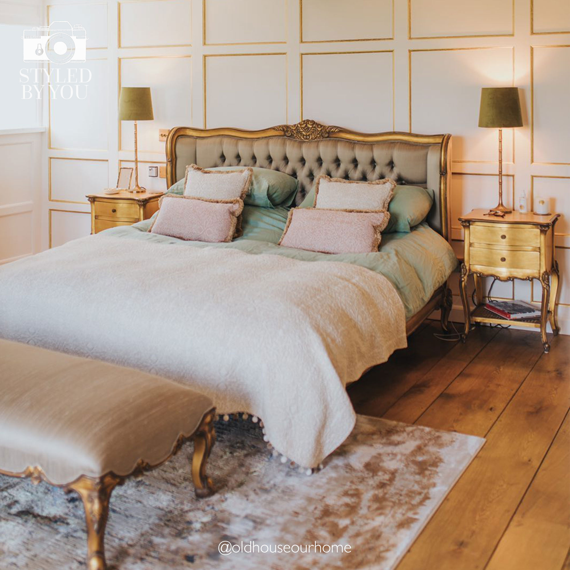 Elegant bedroom with a tufted headboard, plush bedding, wooden nightstands, and a bench. Warm lighting and paneled walls enhance the cozy ambiance.