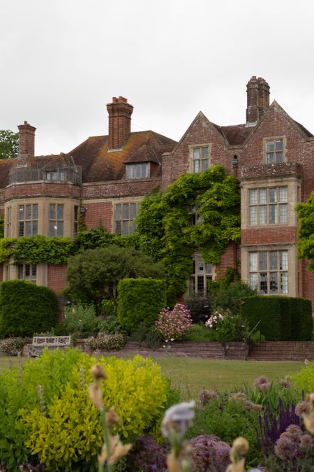A Stunning architectural image of Glyndebourne's Tudor site surrounded by greenery and roses