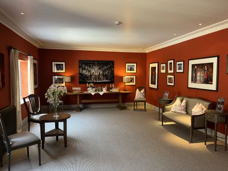 Glyndebourne's elegant red room featuring our Gustavian dark furniture.
