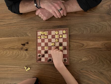 Child playing chess with his father