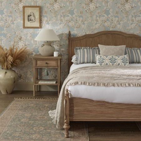 Solid wood French bed beside a matching bedside table, both with carved and intricate detailing.