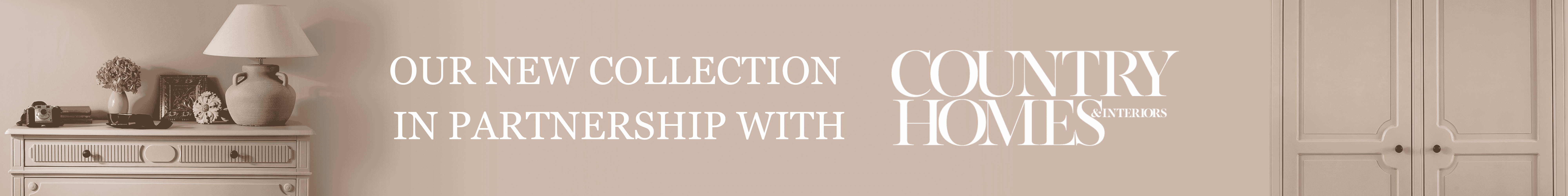 Banner featuring text: "Our New Collection in Partnership with Country Homes & Interiors," beside a table lamp and home d&eacute;cor on a chest of drawers, plus a matching armoire wardrobe.