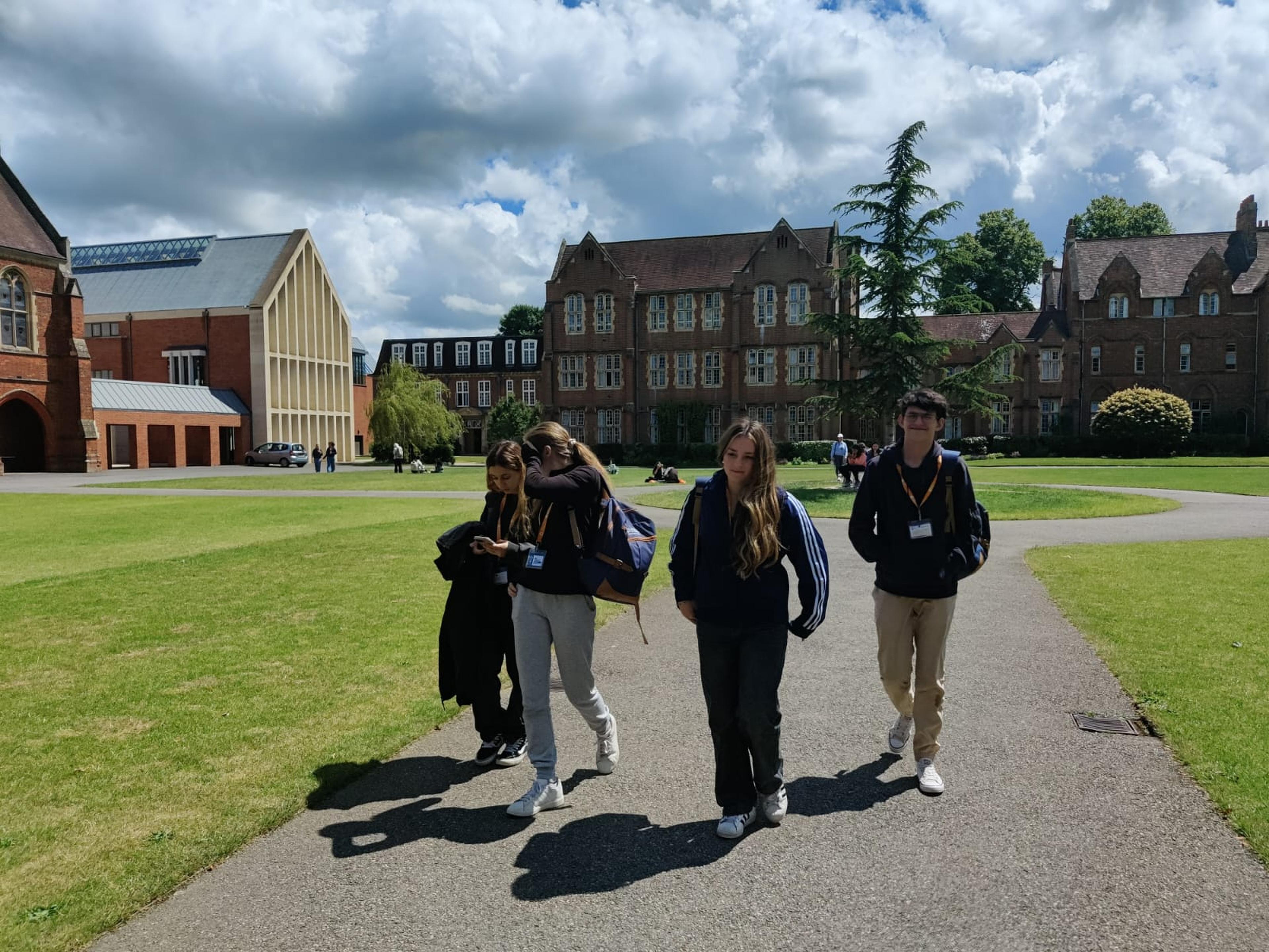 Grupo de estudiantes caminando por un campus universitario en Reino Unido durante un programa educativo internacional.
