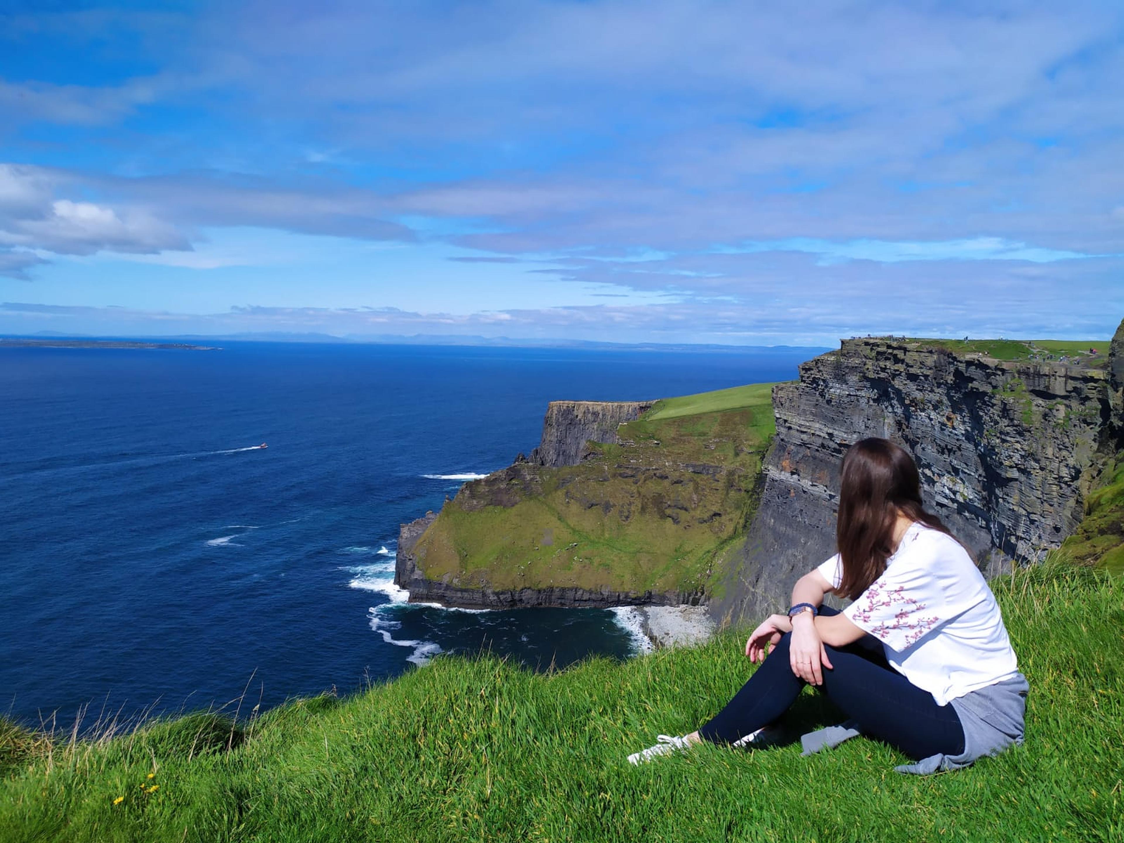 Estudiante disfrutando los acantilados de Irlanda durante su experiencia de estudiar y trabajar en el país