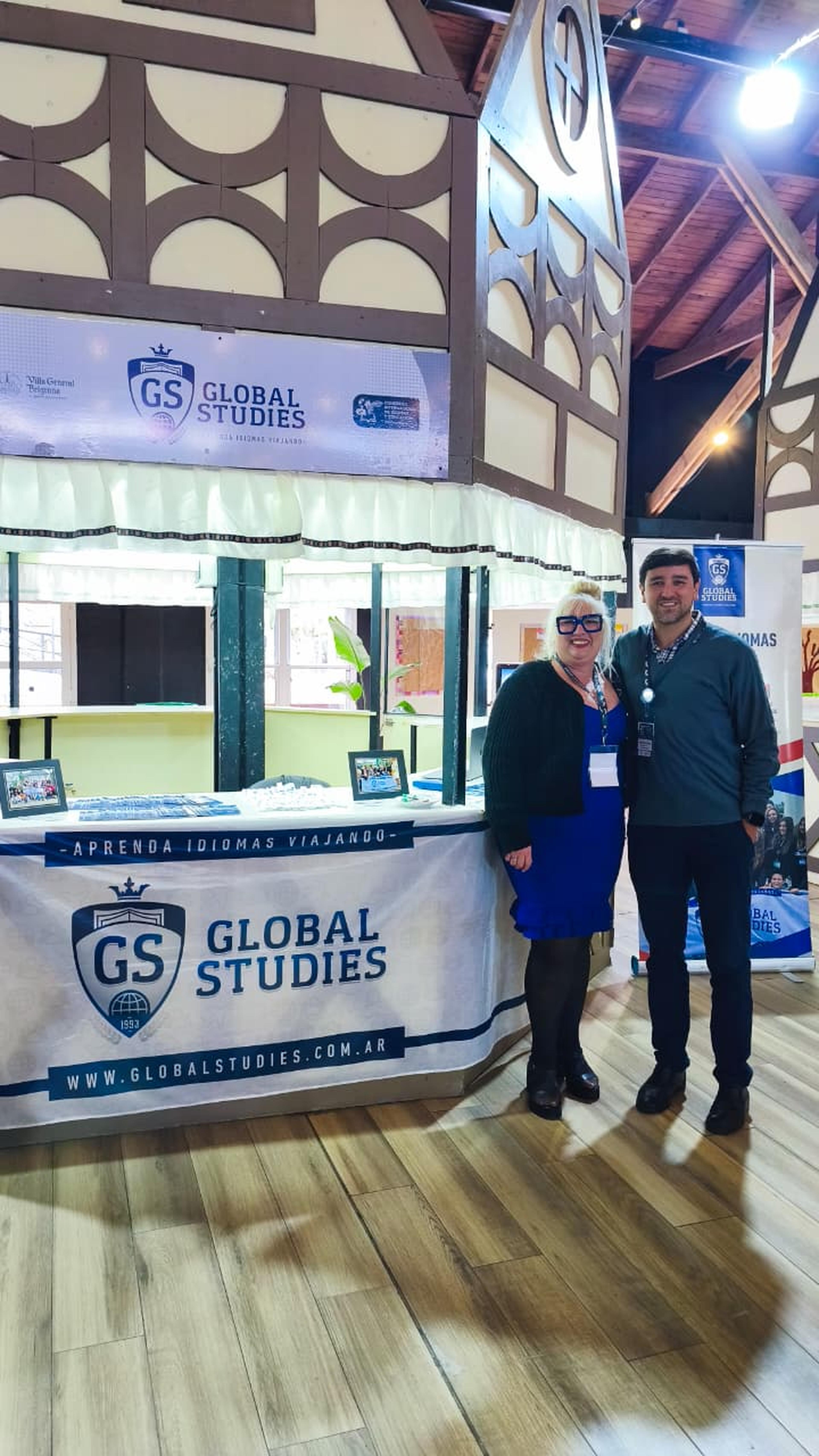 Rodrigo junto a una participante frente al stand de Global Studies en el Congreso de Idiomas de Villa General Belgrano.
