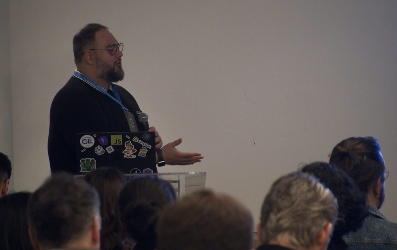 Two presenters from Virgin Media O2 presenting slides and a demo to attendees in a breakout room at JoyConf NY