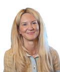 Smiling woman with long blonde hair, wearing a light brown jacket.