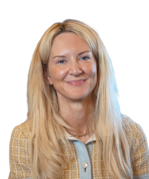 Smiling woman with long blonde hair, wearing a light brown jacket.