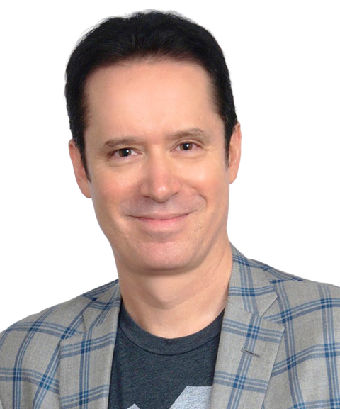Smiling man with dark hair wearing a plaid blazer and a dark t-shirt, looking directly at the camera.