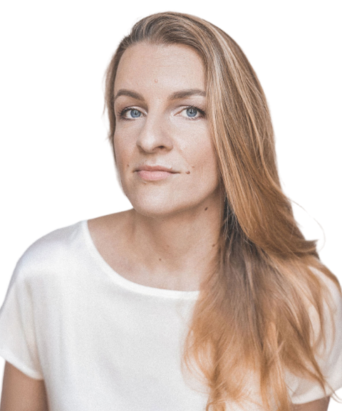 A woman with long, light brown hair wearing a white shirt, looking directly at the camera with a neutral expression against a plain background.