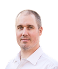 Balding man with short hair in a white shirt, looking at the camera against a white background.